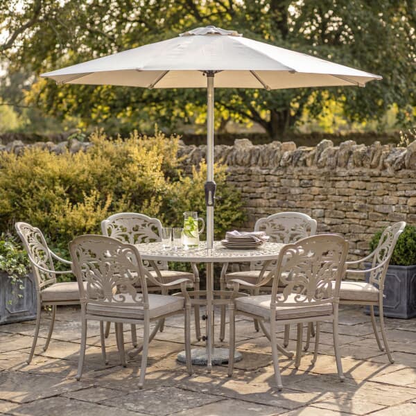 Bramblecrest Venice 136cm Round Dining Table with 6 Stacking Armchairs Parasol And Base In Stone